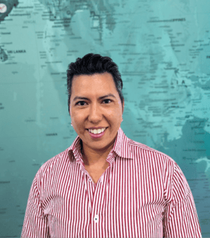 Experienced business professional standing in front of a world map, representing United Franchise Group's global franchise opportunities and business growth solutions.